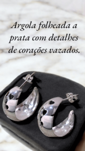 Argola larga folheada a prata com detalhe de corações vazados.