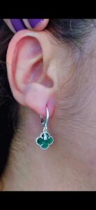 Argola com pingente de trevo na cor verde, folheado a prata.