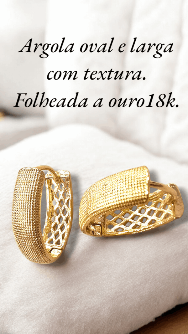 Argola oval e larga com textura. Folheada a ouro18k.
